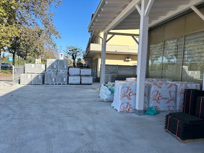 Pallet di pavimentazioni e materiali per esterni sotto la tettoia del deposito